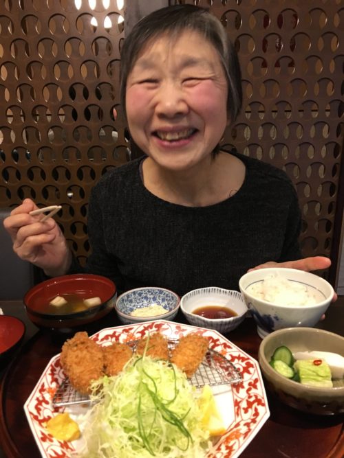 母とカキフライを食べに行ったときの写真。正面に母、母の目の前にはカキフライ定食。満面の笑み。Asacoお気に入りの写真。