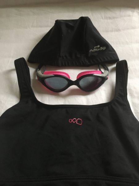 黒の競泳用水着、縁がピンクのゴーグル、黒の水泳帽。マイプールセット。